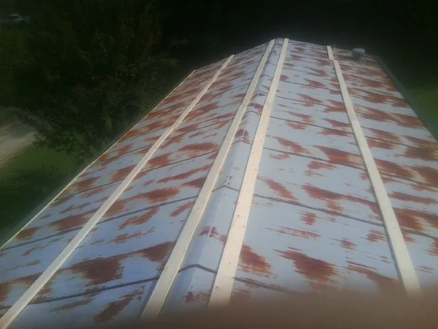 Rusted metal roof panels with new wood purlins before replacement — Storm Damage Roof Repair in East Killingly by Roofing Brothers