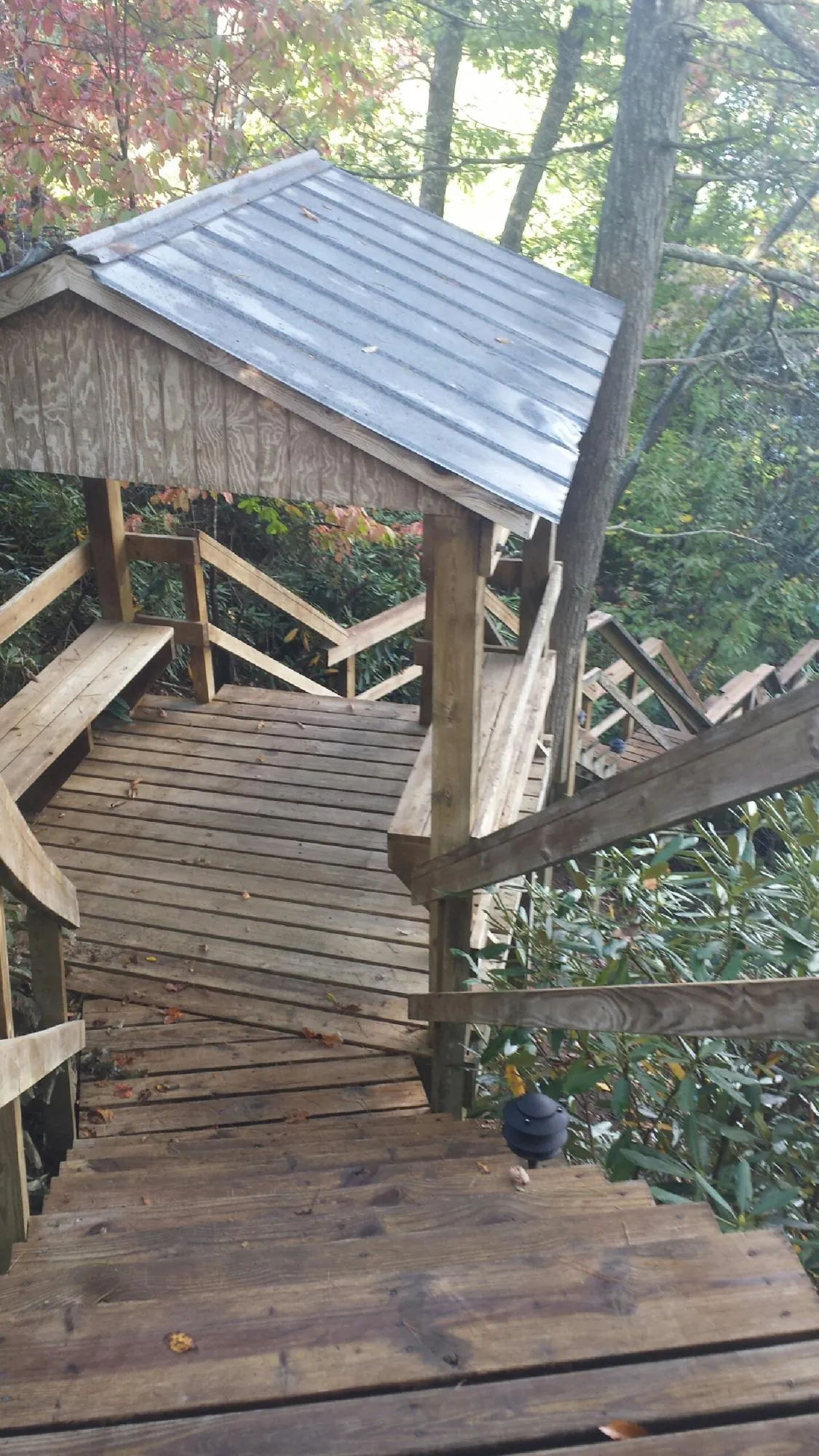 Metal roofed shelter over wooden steps on a wooded walkway — Skylight Repair & Installation work by our crew in East Killingly