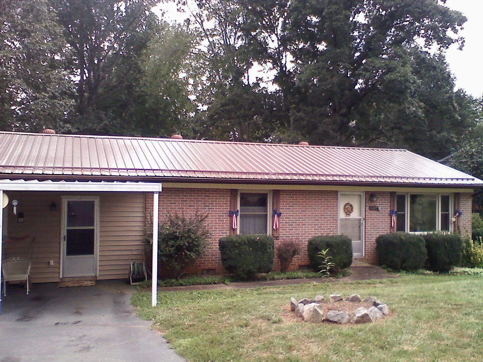 Bronze metal roof and carport on a brick ranch home — Roof Repair work by our crew in East Killingly